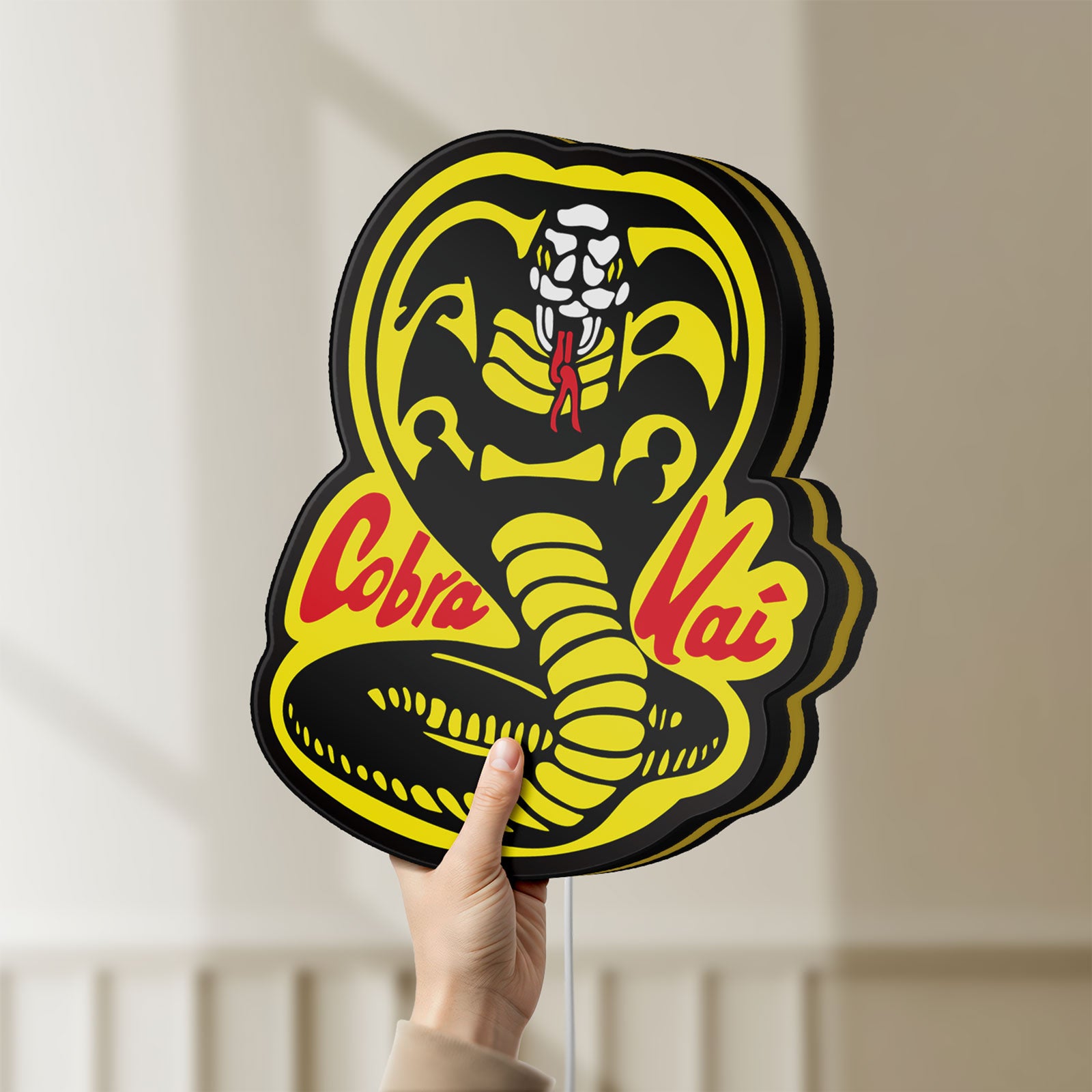 Unlit Cobra Kai LED lightbox held by hand to show size and details