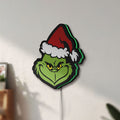 Unlit Grinch LED lightbox mounted on a wall in daylight