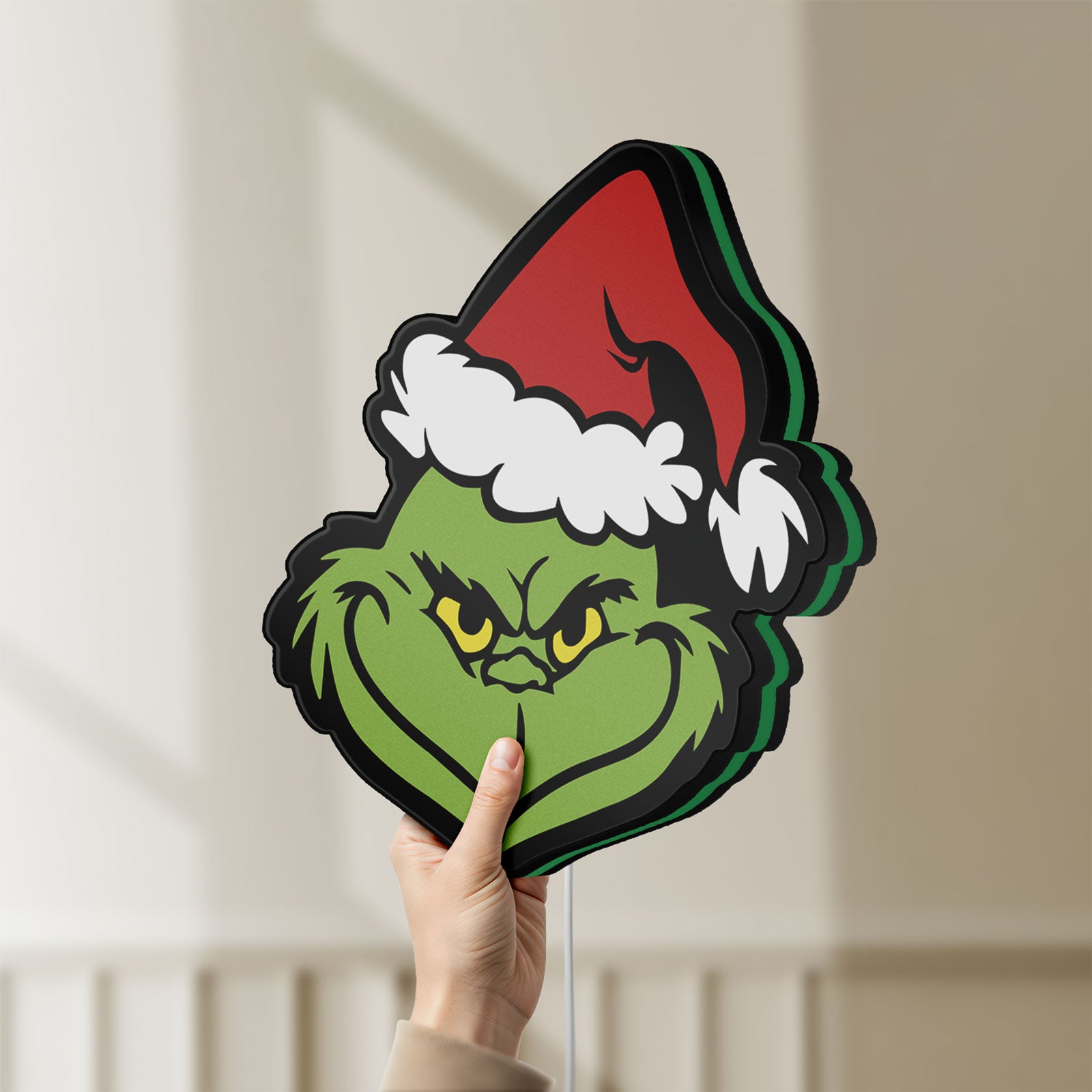 Unlit Grinch LED lightbox held by hand to show size and details