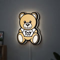 Oso Moschino Toy LED lightbox hanging on a wall with white glow