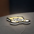 Oso Moschino Toy LED lightbox lying flat on a desk with white glow