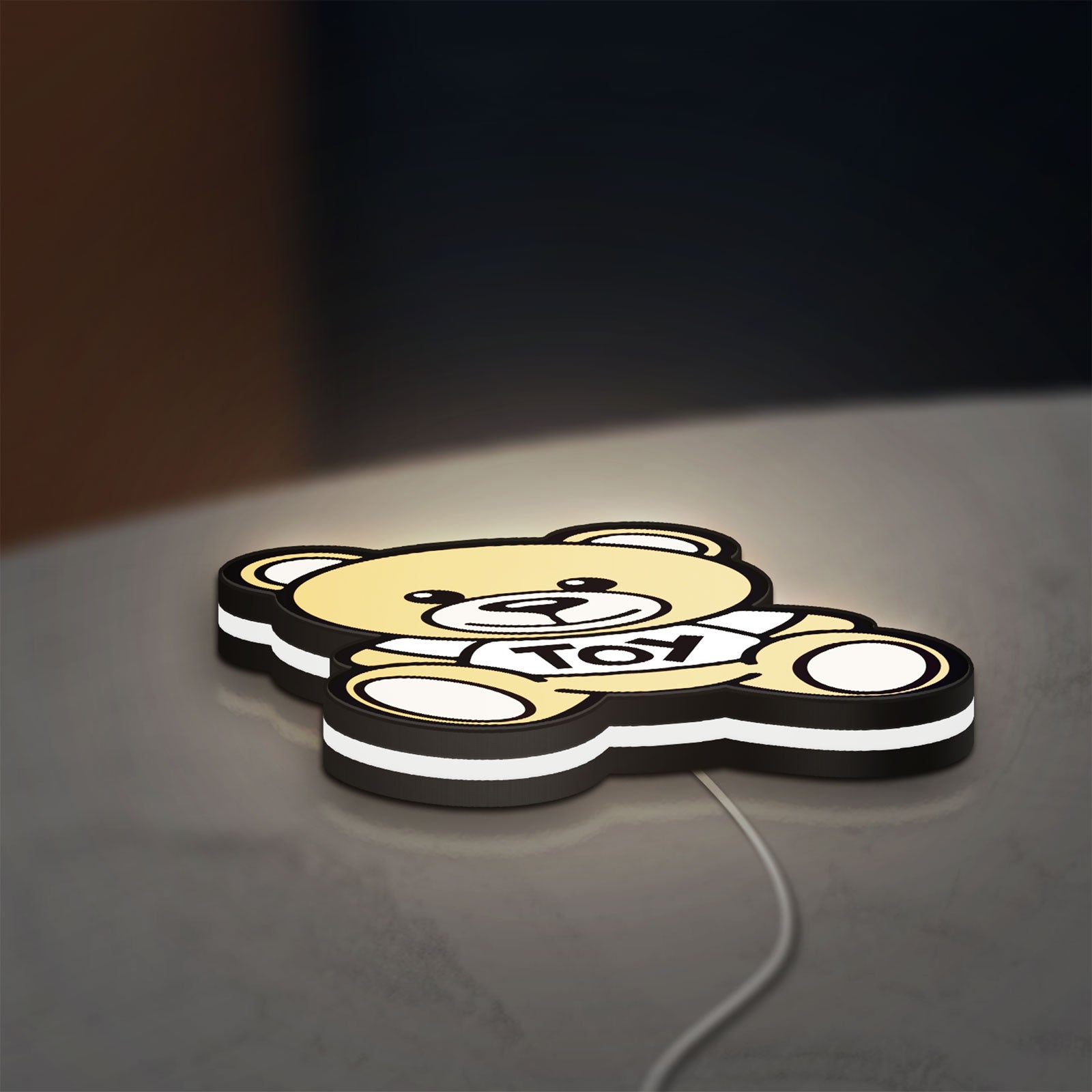 Oso Moschino Toy LED lightbox lying flat on a desk with white glow