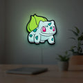 Bulbasaur LED lightbox hanging on a room wall with soft green light