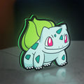 Bulbasaur LED lightbox standing on a desk from an angled side view with green glow