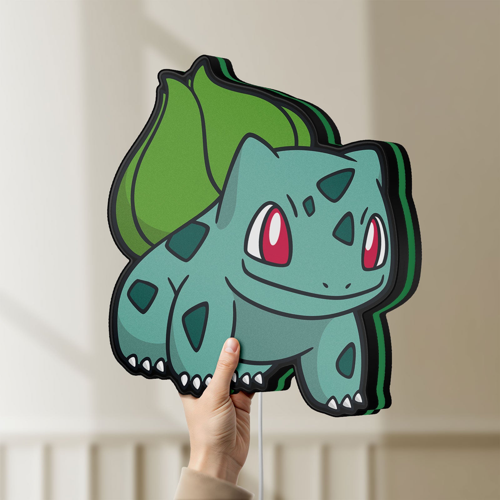 Unlit Bulbasaur LED lightbox held by hand to show size and details