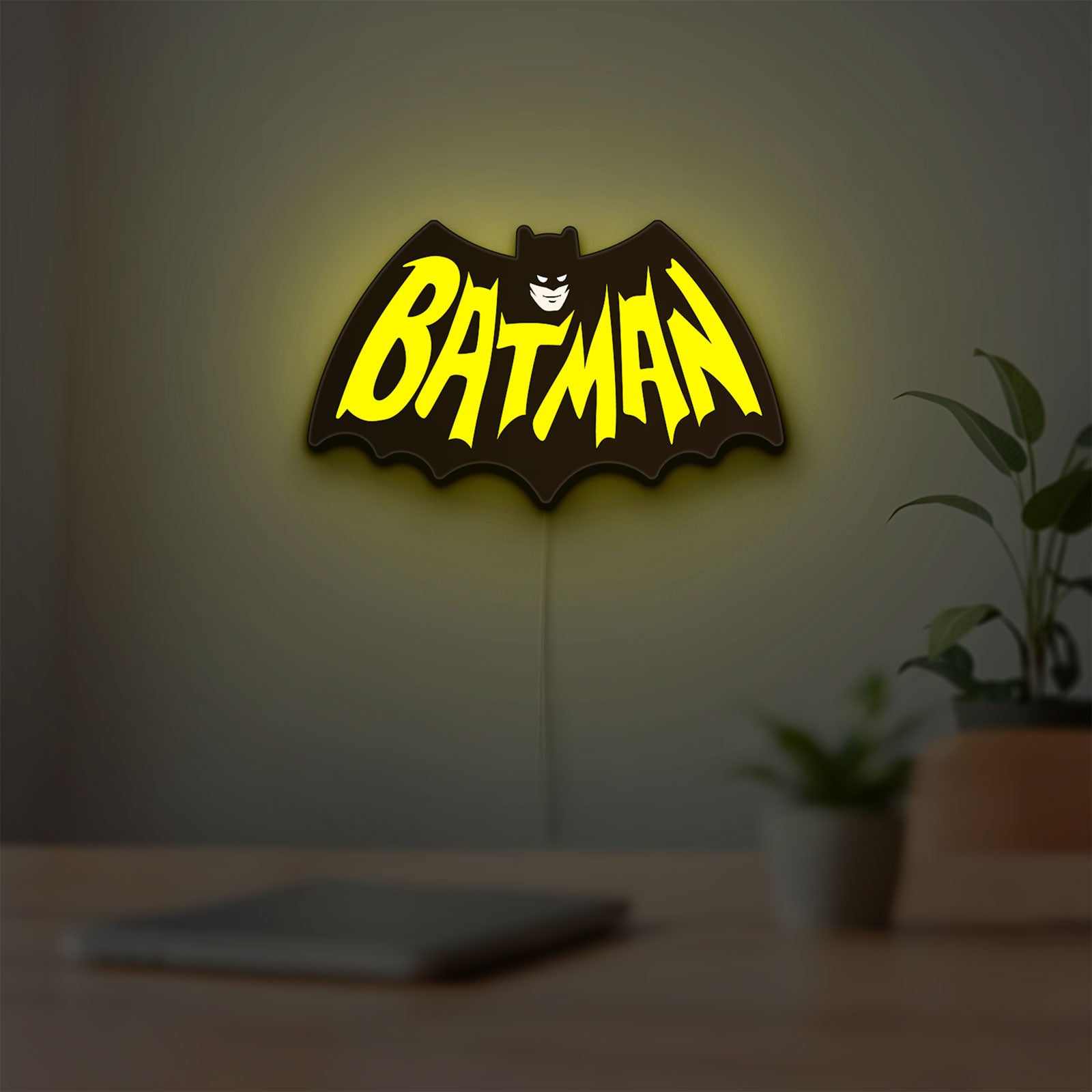 Batman LED lightbox hanging on a room wall with soft yellow light