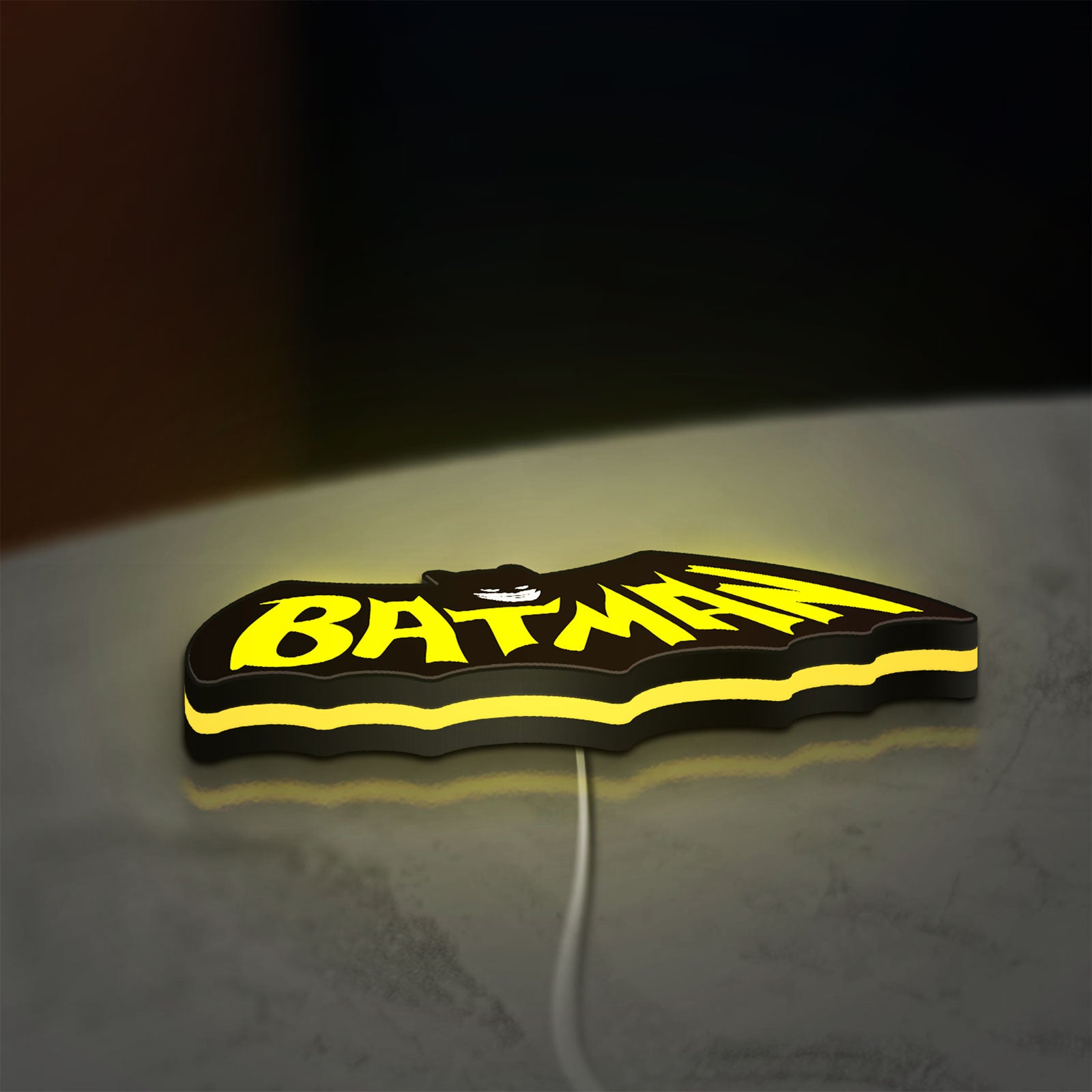 Batman LED lightbox lying flat on a desk with yellow glow