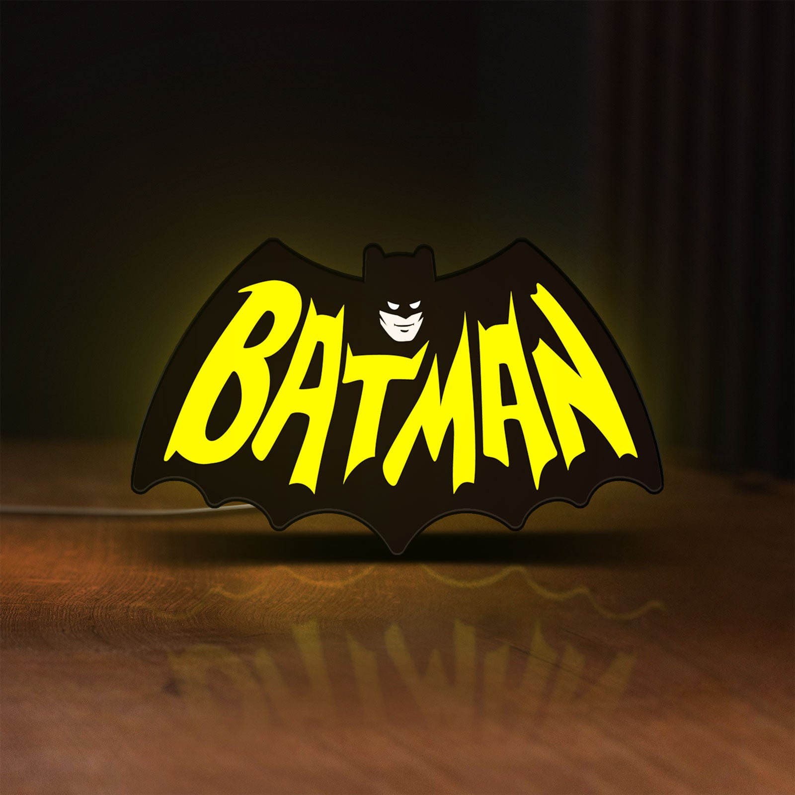 Front view of Batman LED lightbox sign glowing on a wooden desk