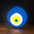 Front view of Nazar Boncugu LED lightbox sign glowing on a wooden desk