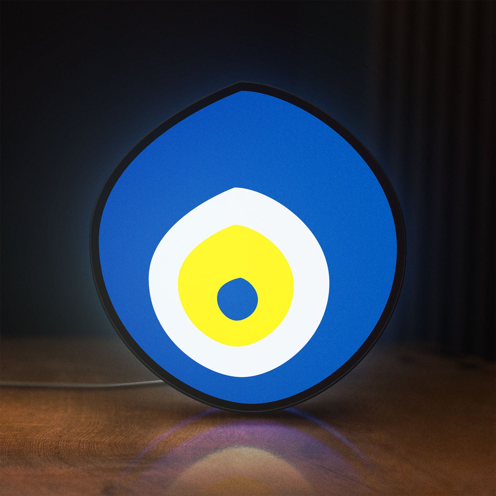 Front view of Nazar Boncugu LED lightbox sign glowing on a wooden desk