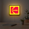 Kodak LED lightbox hanging on a room wall with soft yellow light
