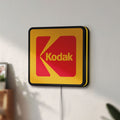 Unlit Kodak LED lightbox mounted on a wall in daylight