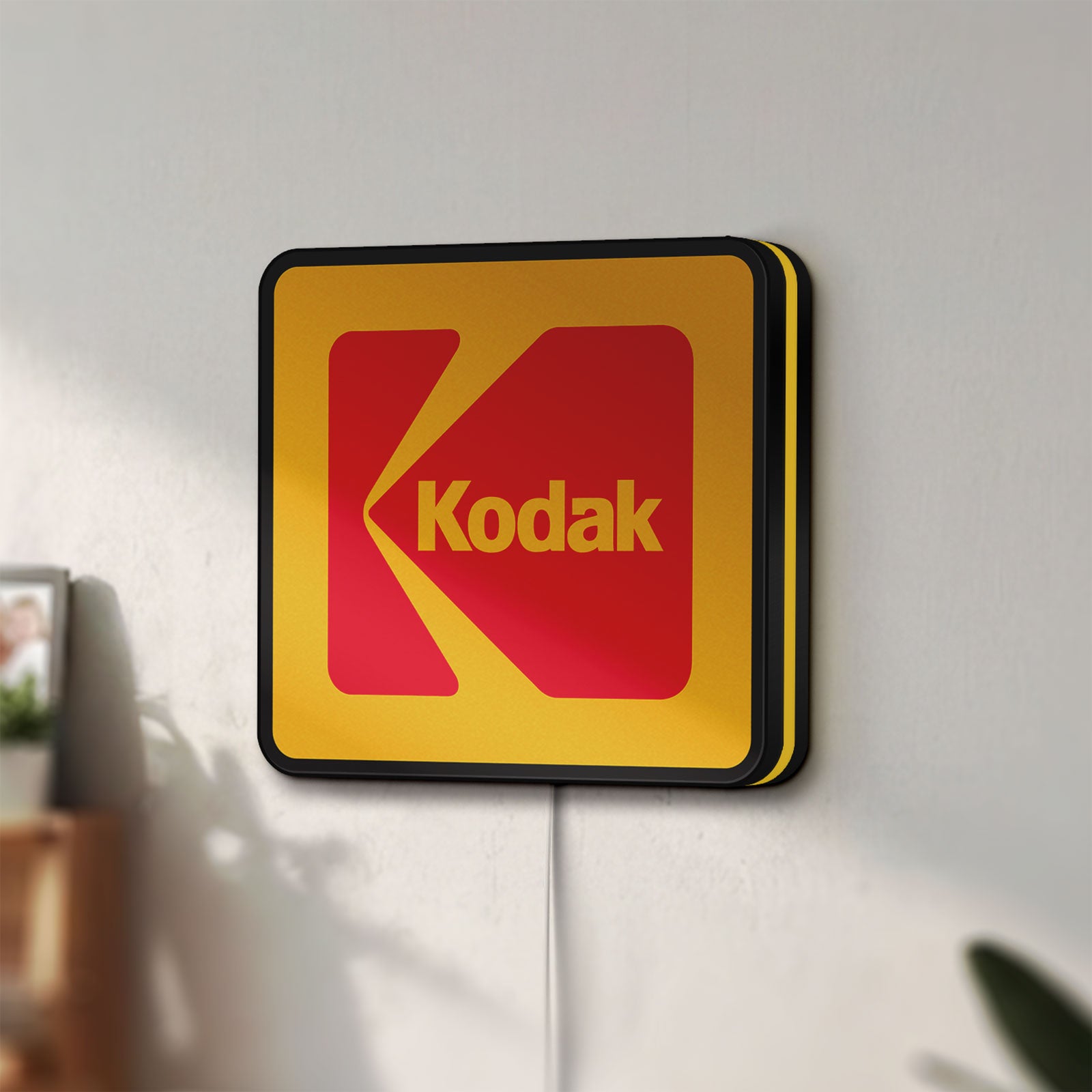Unlit Kodak LED lightbox mounted on a wall in daylight