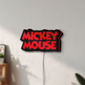 Unlit Mickey Mouse LED lightbox mounted on a wall in daylight