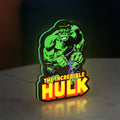 Hulk Smash Fist LED lightbox standing on a desk from an angled side view with green glow
