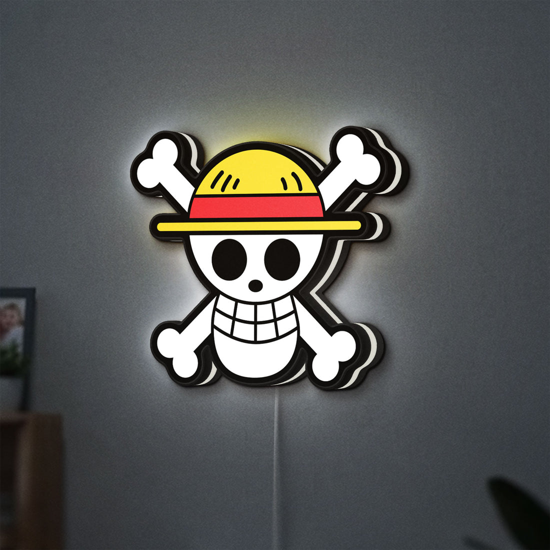 One Piece Skull LED lightbox hanging on a wall with white glow