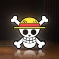 Front view of One Piece Skull LED lightbox sign glowing on a wooden desk