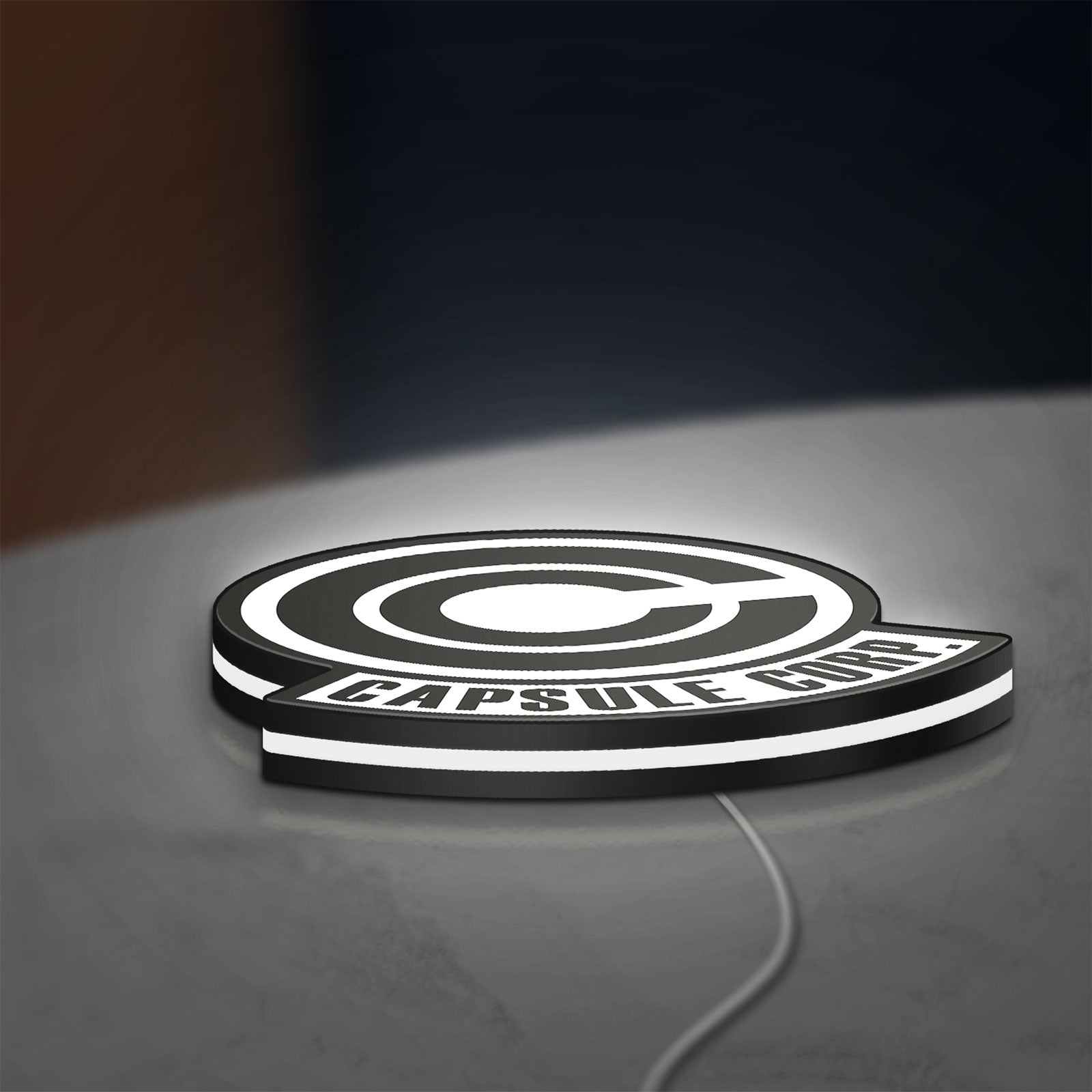 Capsule Corp LED lightbox lying flat on a desk with white glow