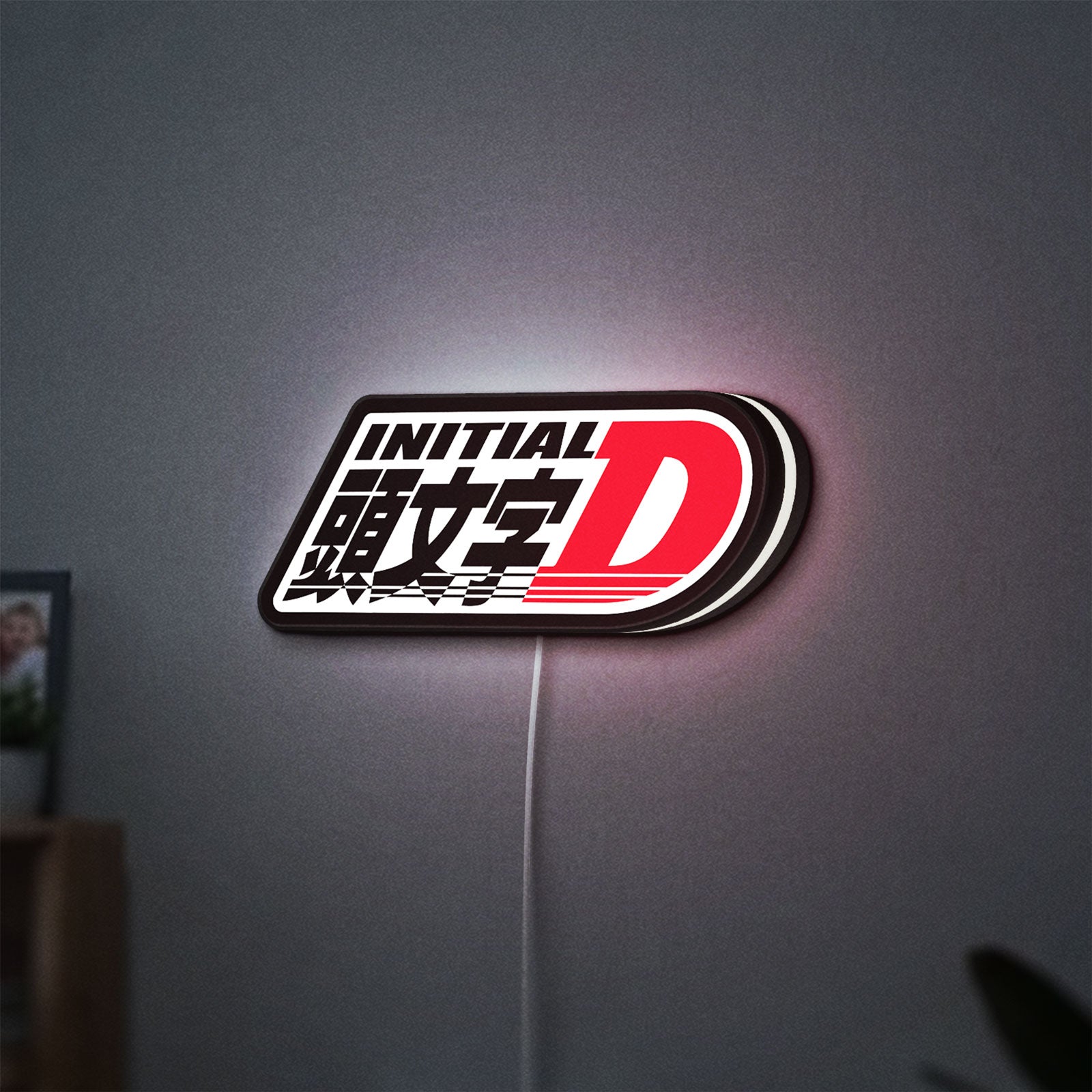 Initial D LED lightbox hanging on a wall with white glow