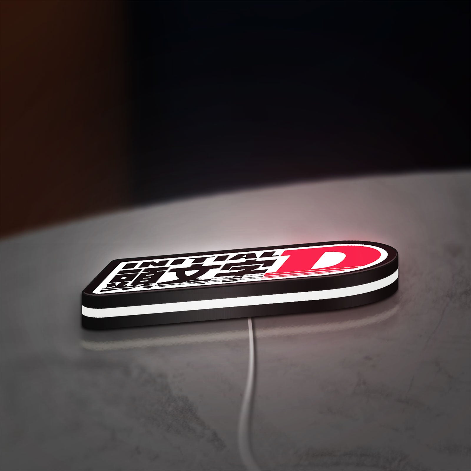 Initial D LED lightbox lying flat on a desk with white glow