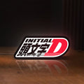 Front view of Initial D LED lightbox sign glowing on a wooden desk