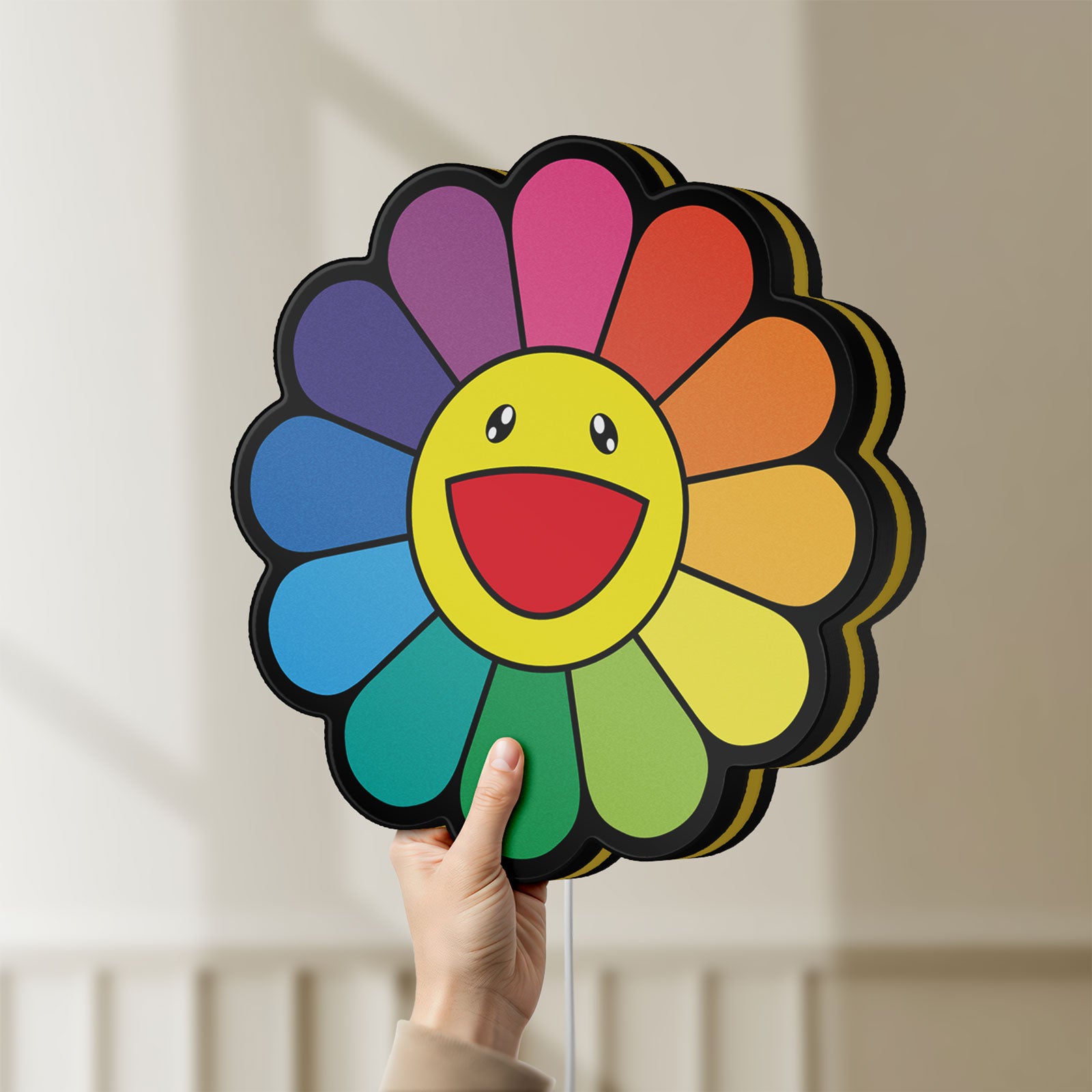 Unlit Takashi Murakami Rainbow Flower LED lightbox held by hand to show size and details