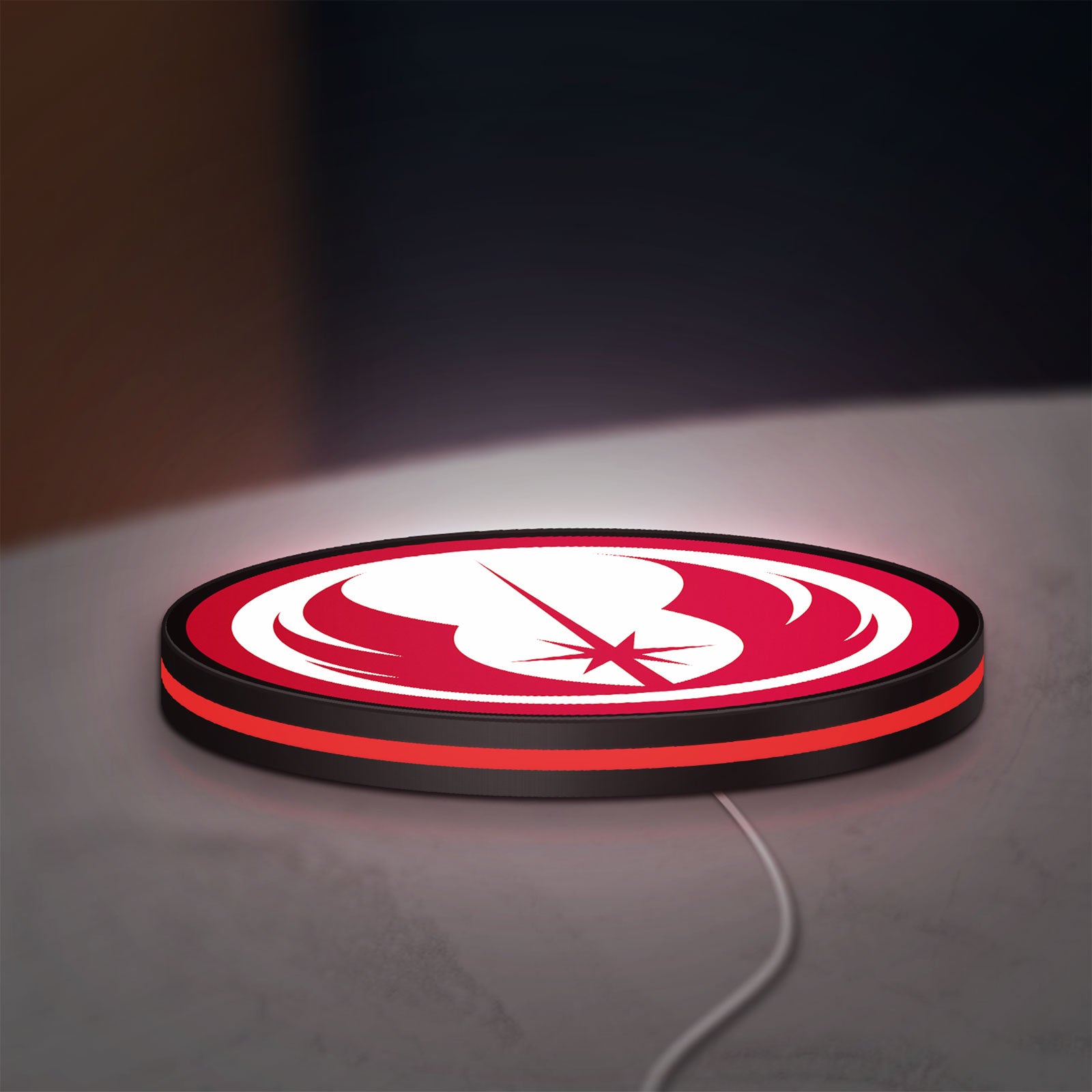 Jedi Order LED lightbox lying flat on a desk with red glow