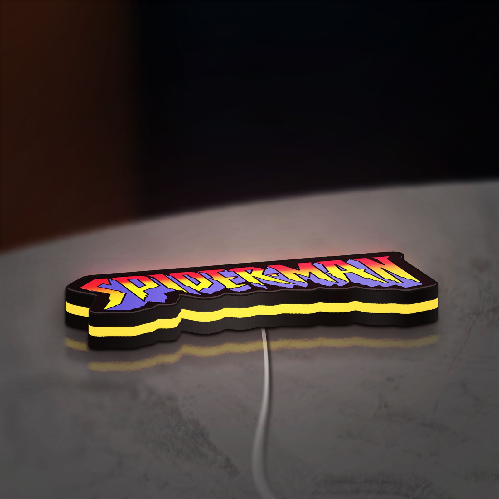 Spider-Man LED lightbox lying flat on a desk with yellow glow