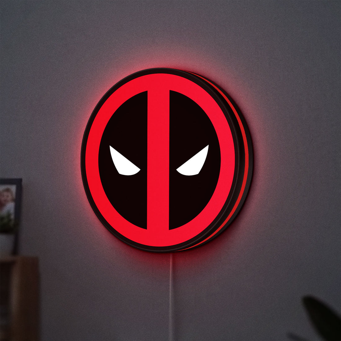 Deadpool LED lightbox hanging on a wall with red glow