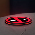 Deadpool LED lightbox lying flat on a desk with red glow