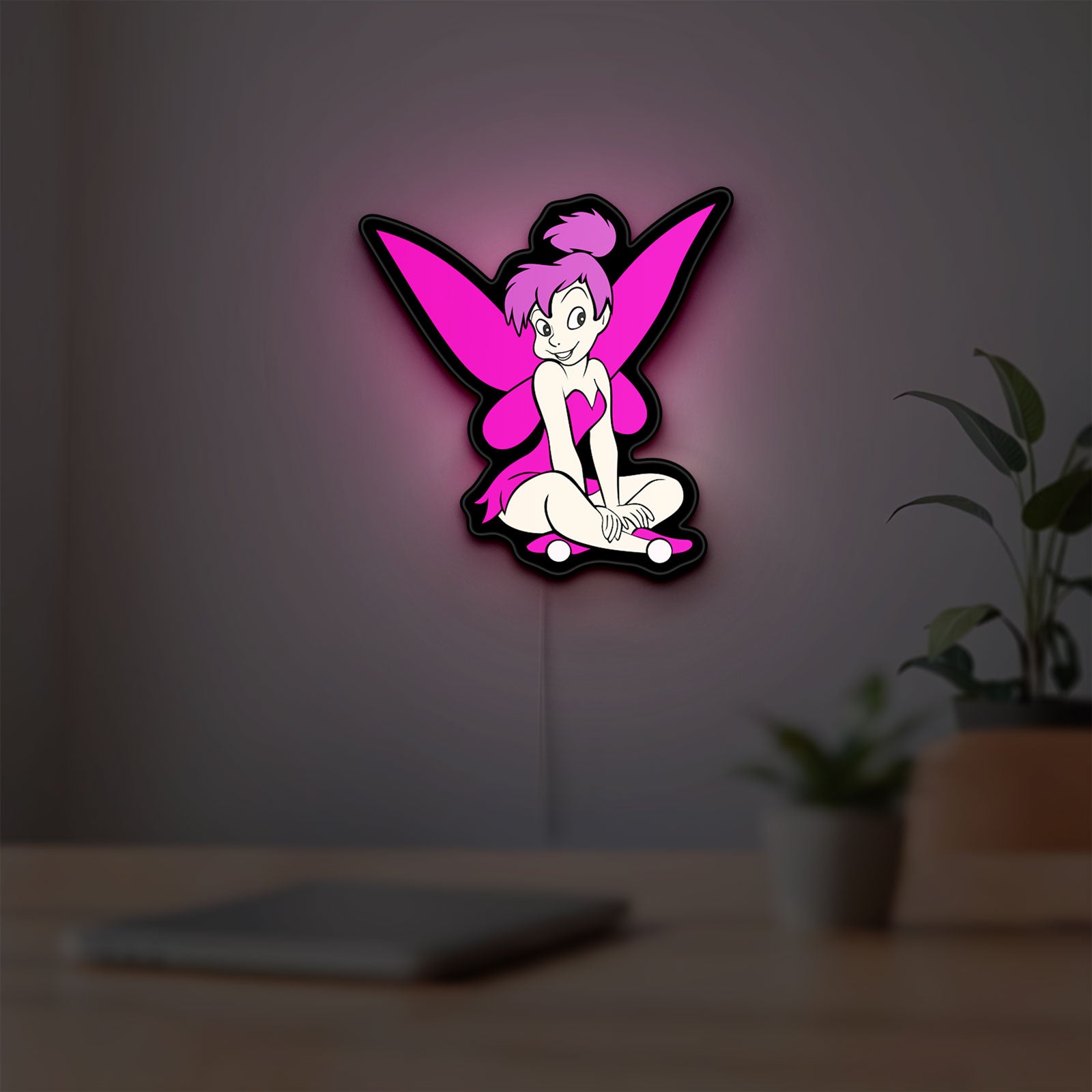 Tinkerbell LED lightbox hanging on a room wall with soft pink light