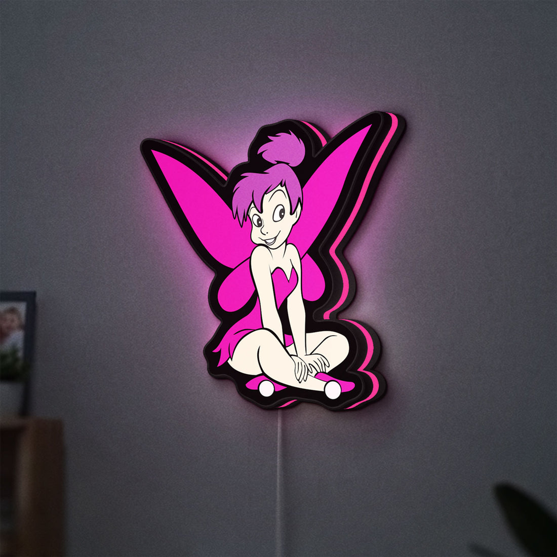 Tinkerbell LED lightbox hanging on a wall with pink glow