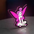 Tinkerbell LED lightbox standing on a desk from an angled side view with pink glow