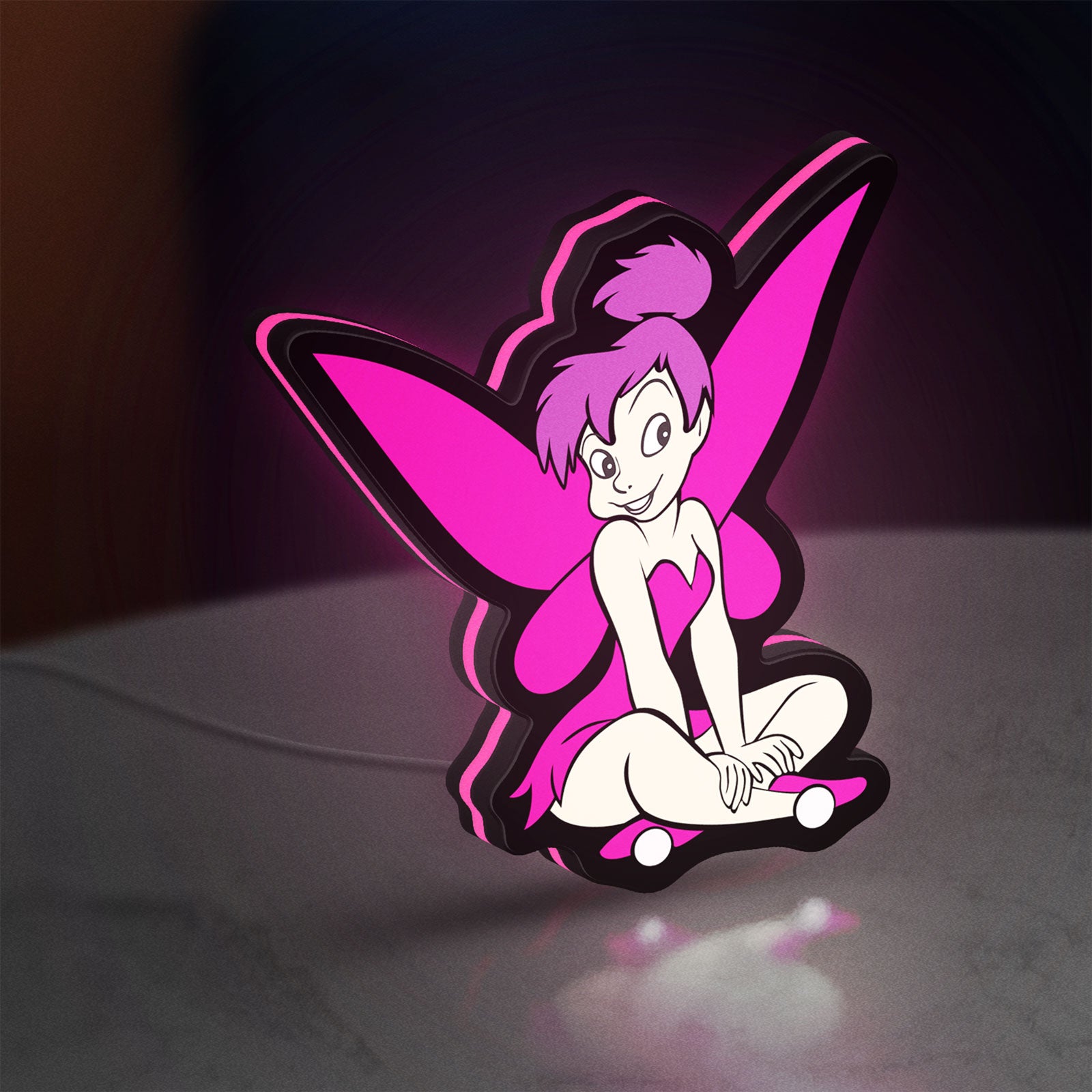 Tinkerbell LED lightbox standing on a desk from an angled side view with pink glow