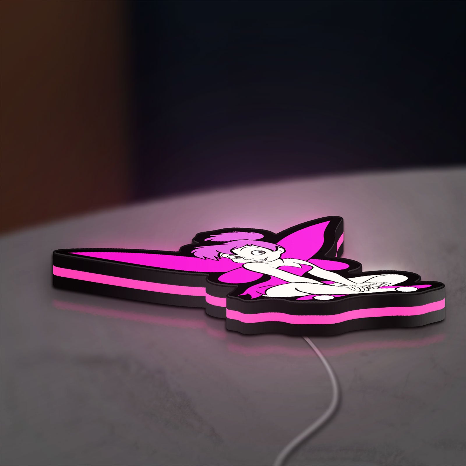 Tinkerbell LED lightbox lying flat on a desk with pink glow