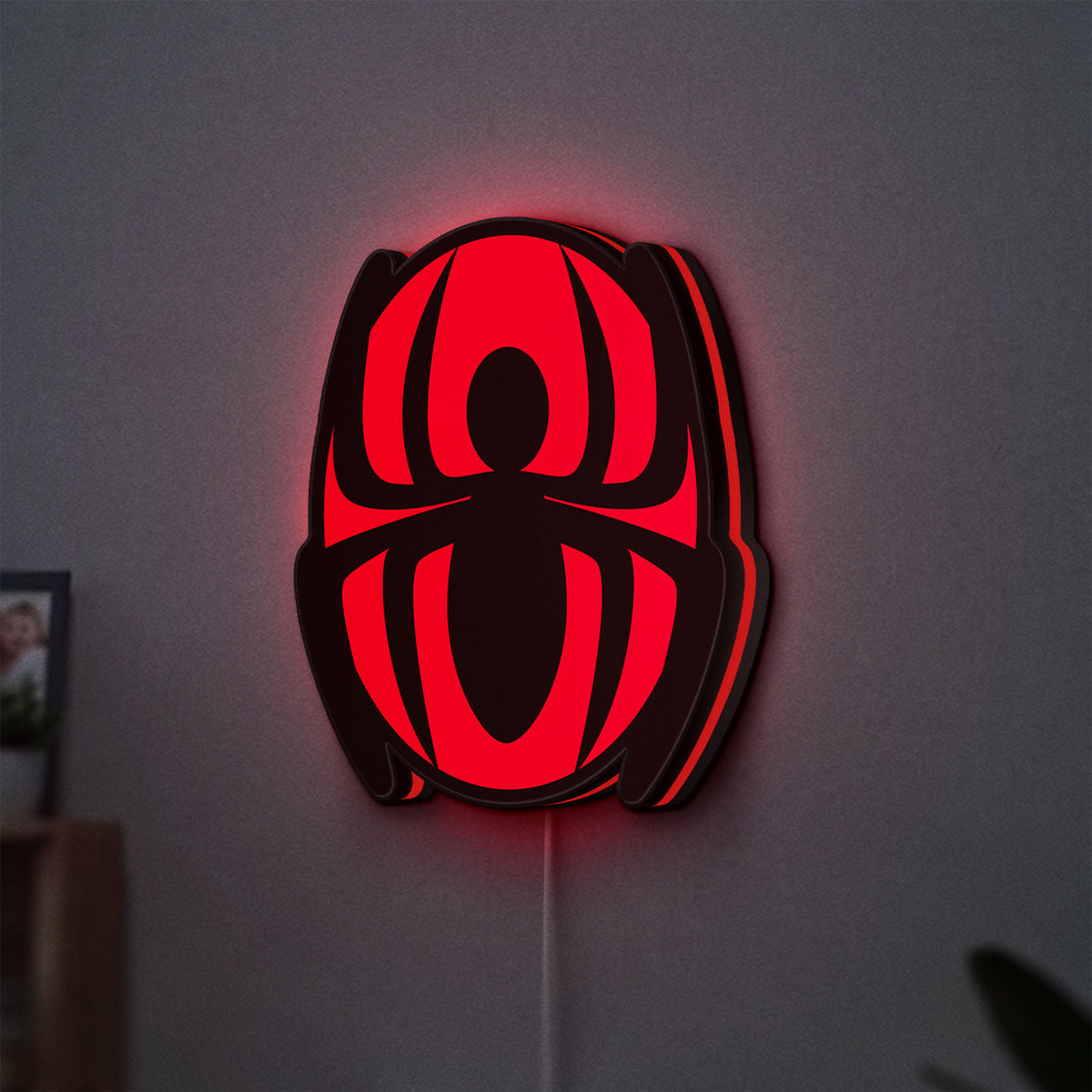 Spider-Man LED lightbox hanging on a wall with red glow
