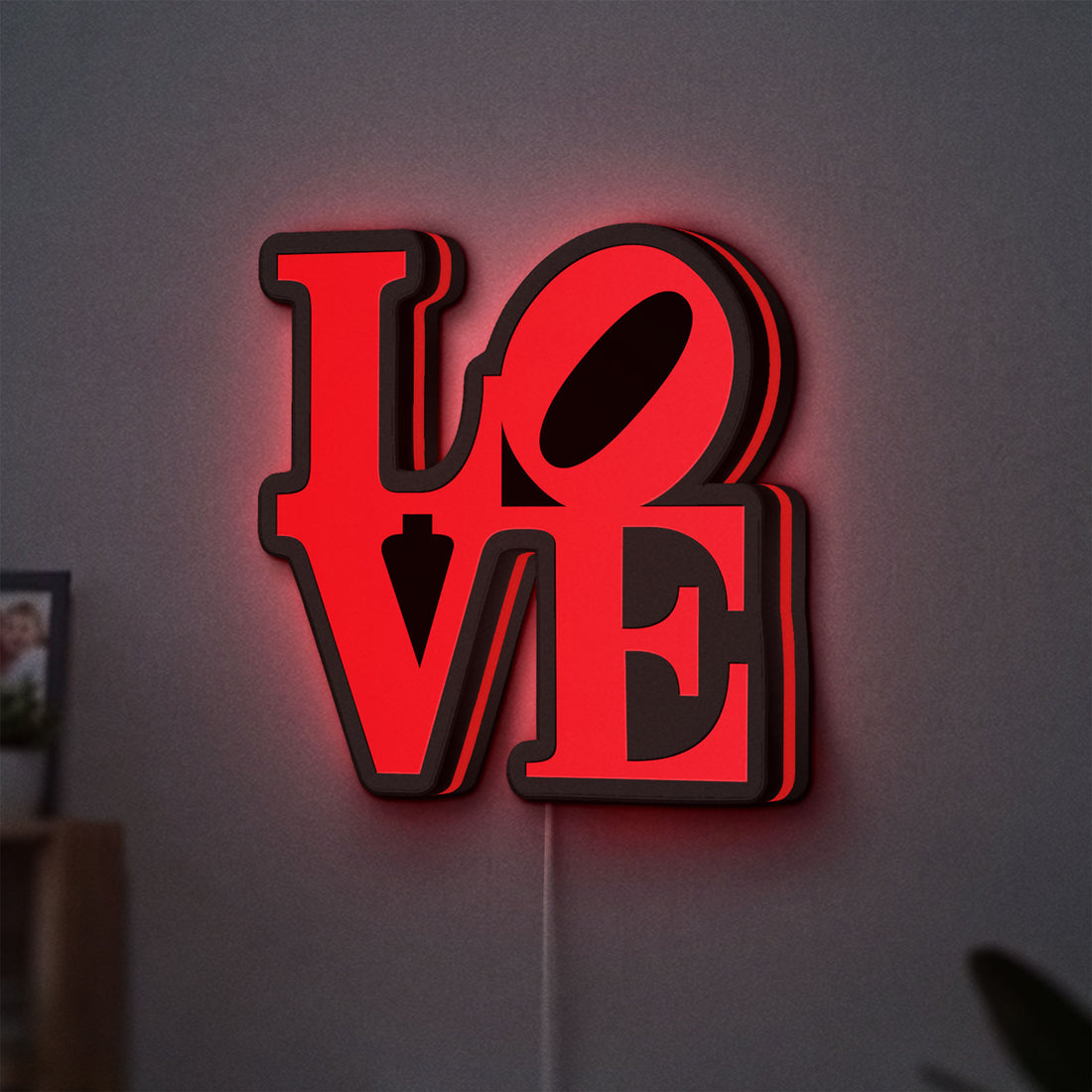 Love LED lightbox hanging on a wall with red glow