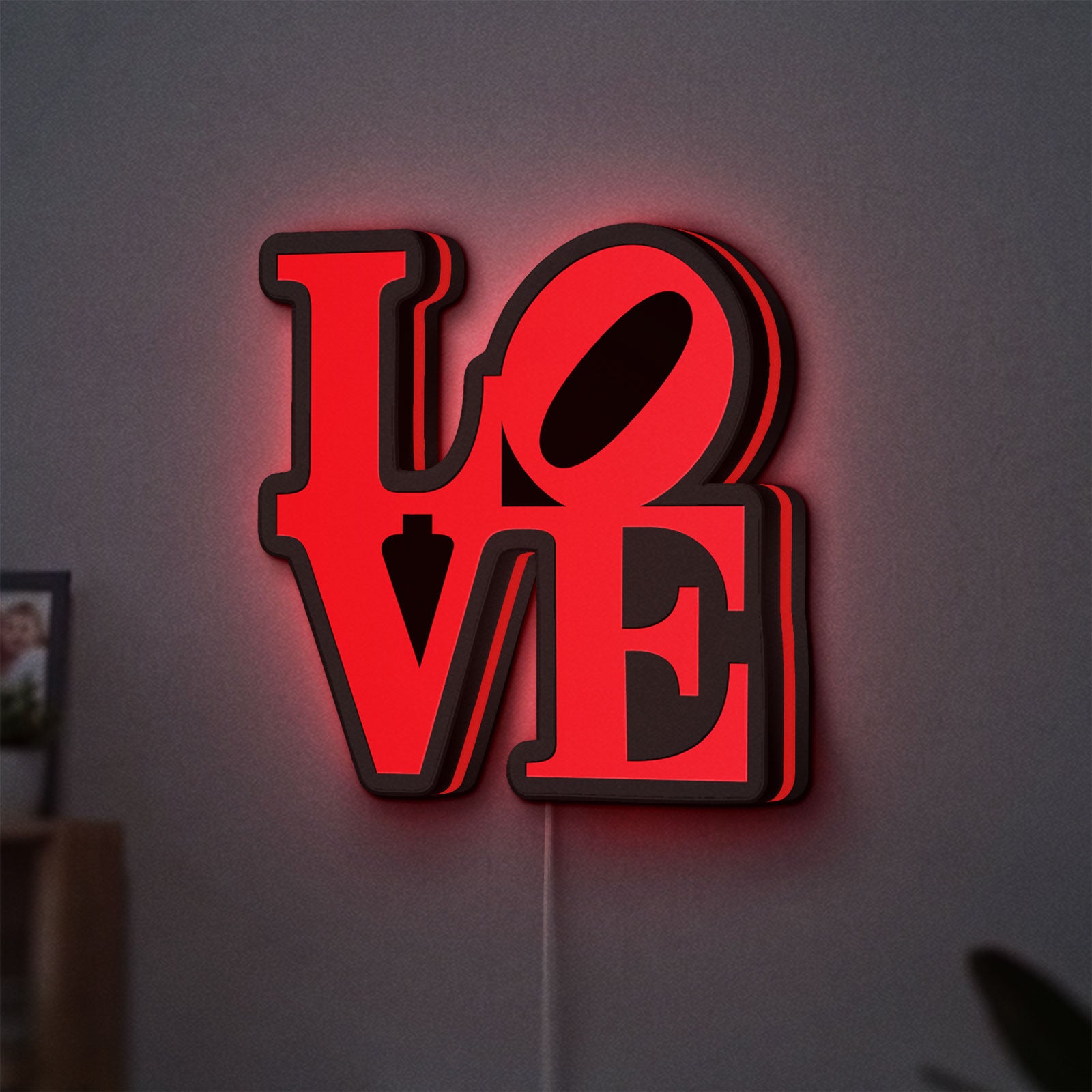 Love LED lightbox hanging on a wall with red glow