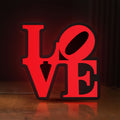 Front view of Love LED lightbox sign glowing on a wooden desk