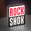 Rock Shox LED lightbox standing on a desk from an angled side view with white glow