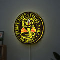 Cobra Kai LED lightbox hanging on a wall with yellow glow