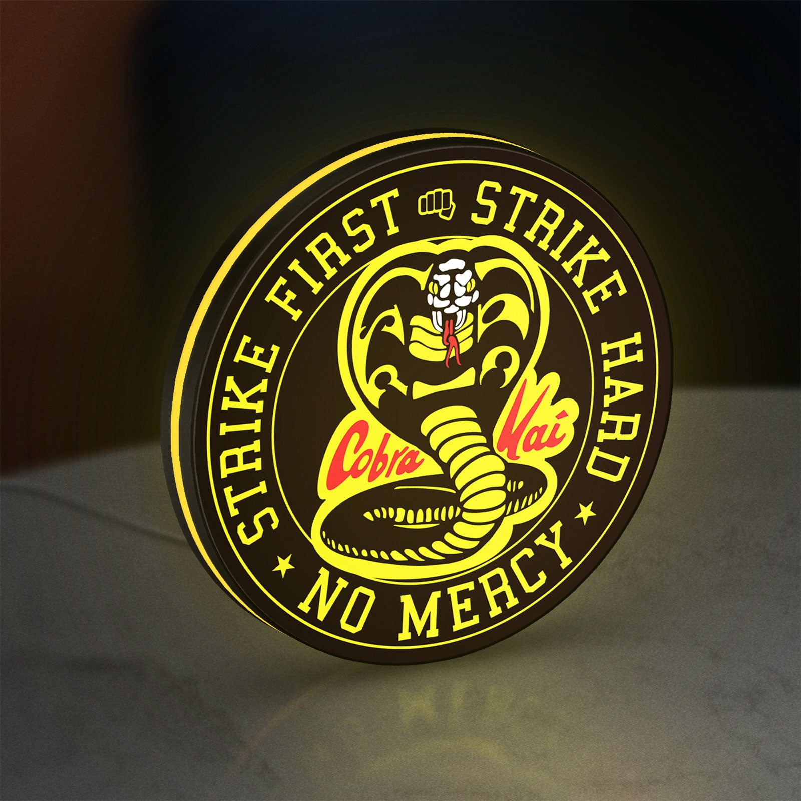 Cobra Kai LED lightbox standing on a desk from an angled side view with yellow glow