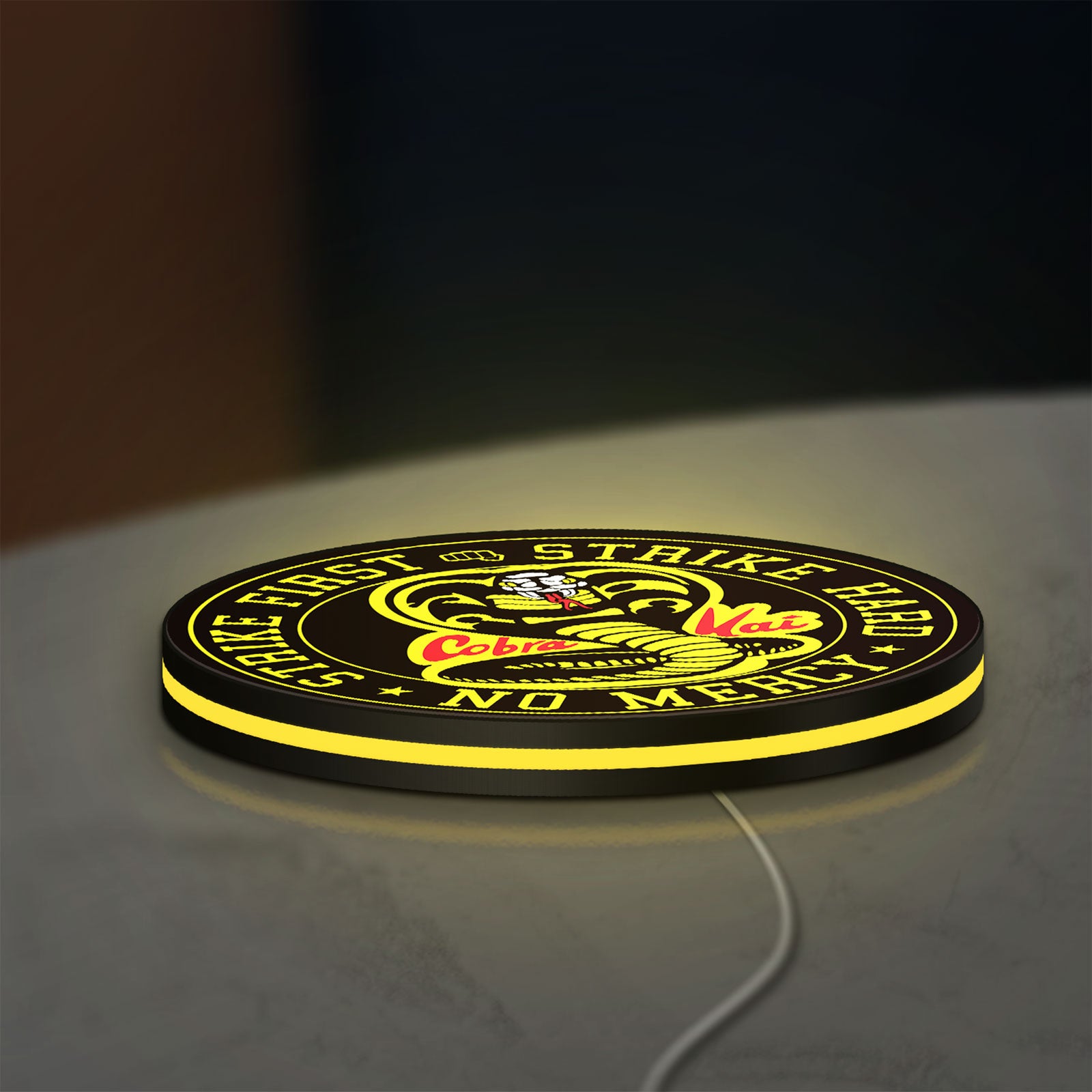 Cobra Kai LED lightbox lying flat on a desk with yellow glow