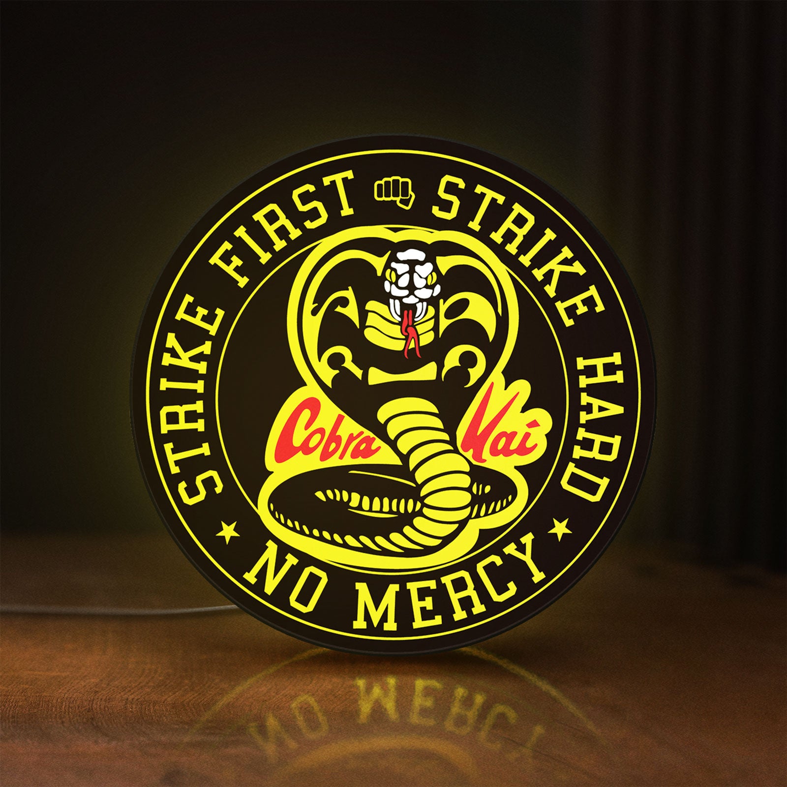 Front view of Cobra Kai LED lightbox sign glowing on a wooden desk