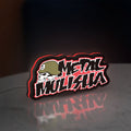 Metal Mulisha LED lightbox standing on a desk from an angled side view with red glow