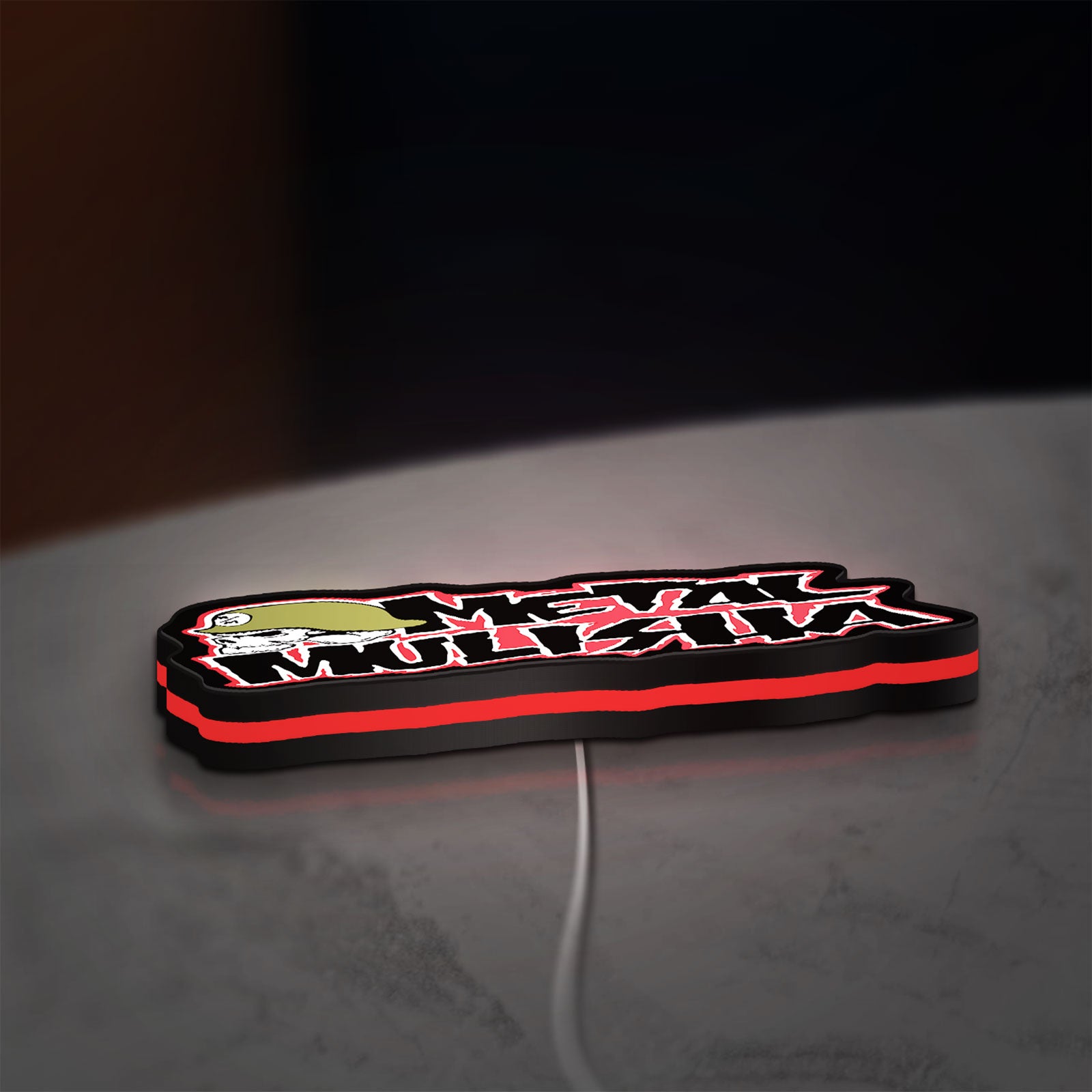 Metal Mulisha LED lightbox lying flat on a desk with red glow