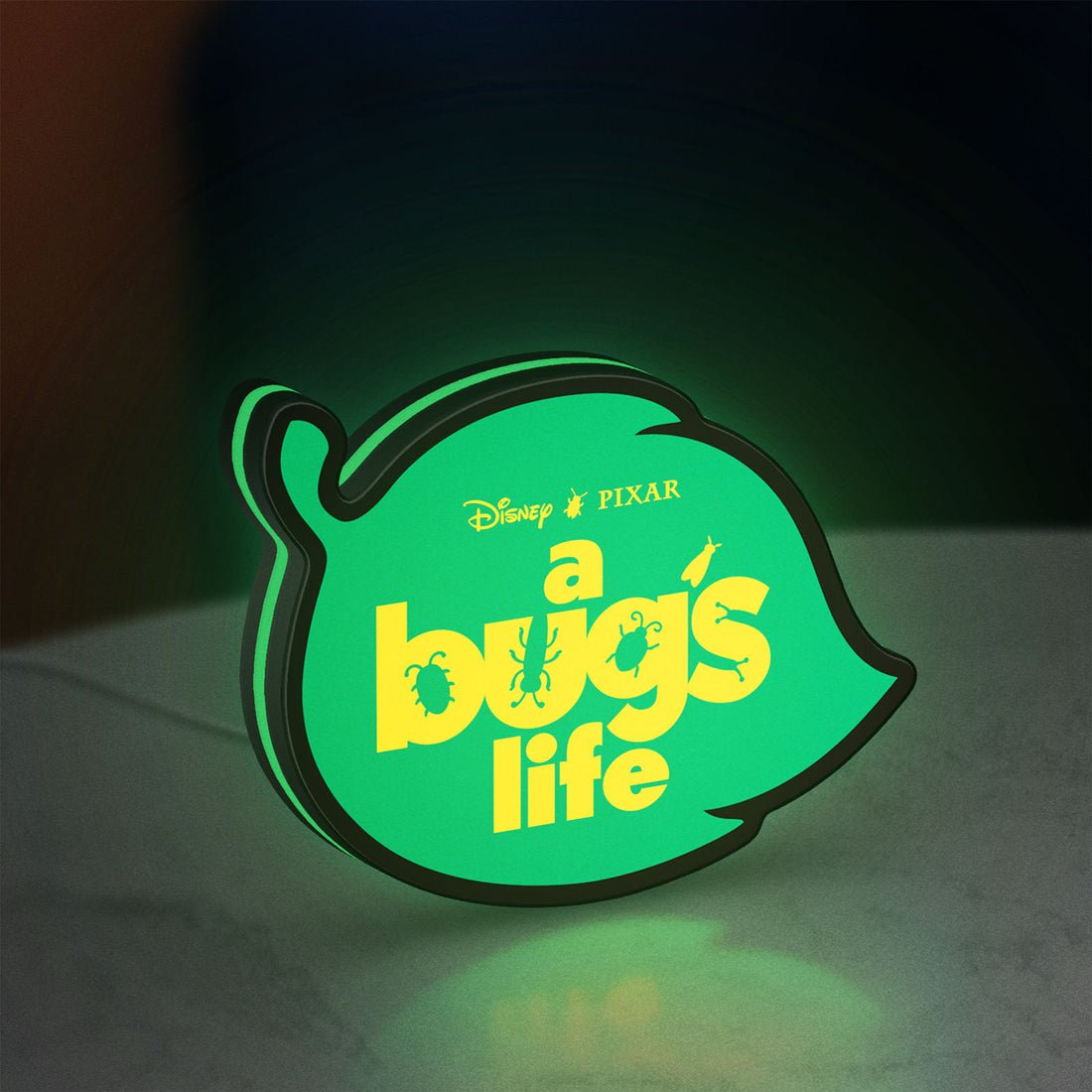 A Bug's Life LED lightbox hanging on a wall with green glow