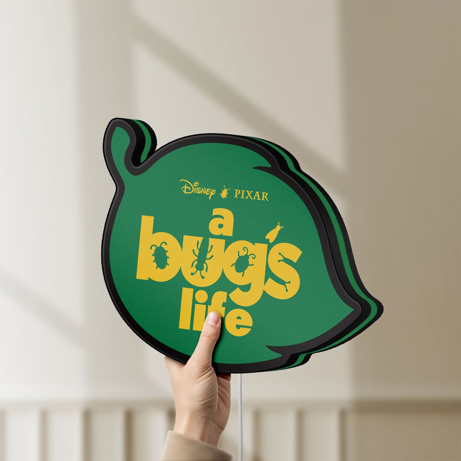 Unlit A Bug's Life LED lightbox held by hand to show size and details