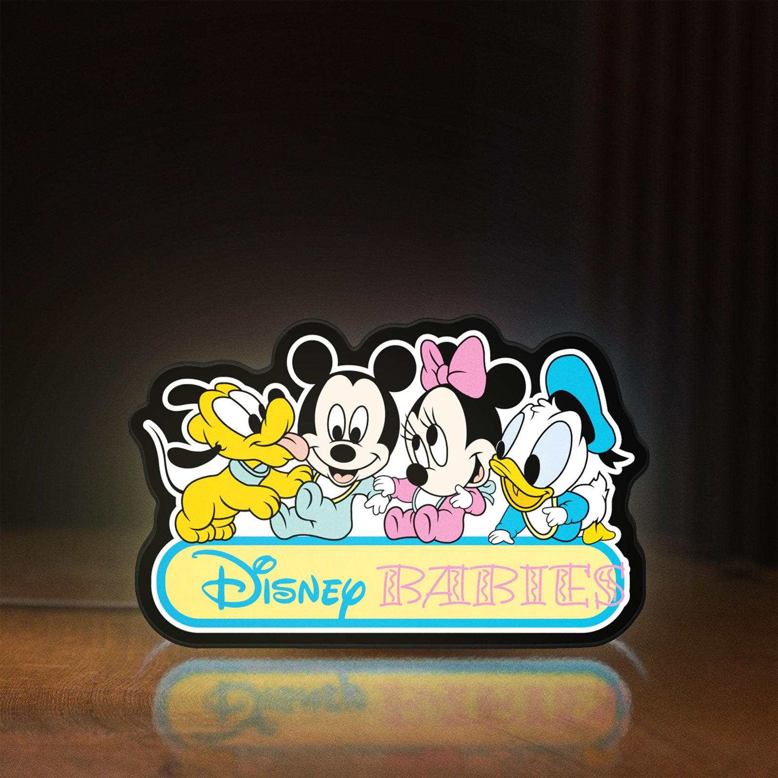 Front view of Disney Babies LED lightbox sign glowing on a wooden desk