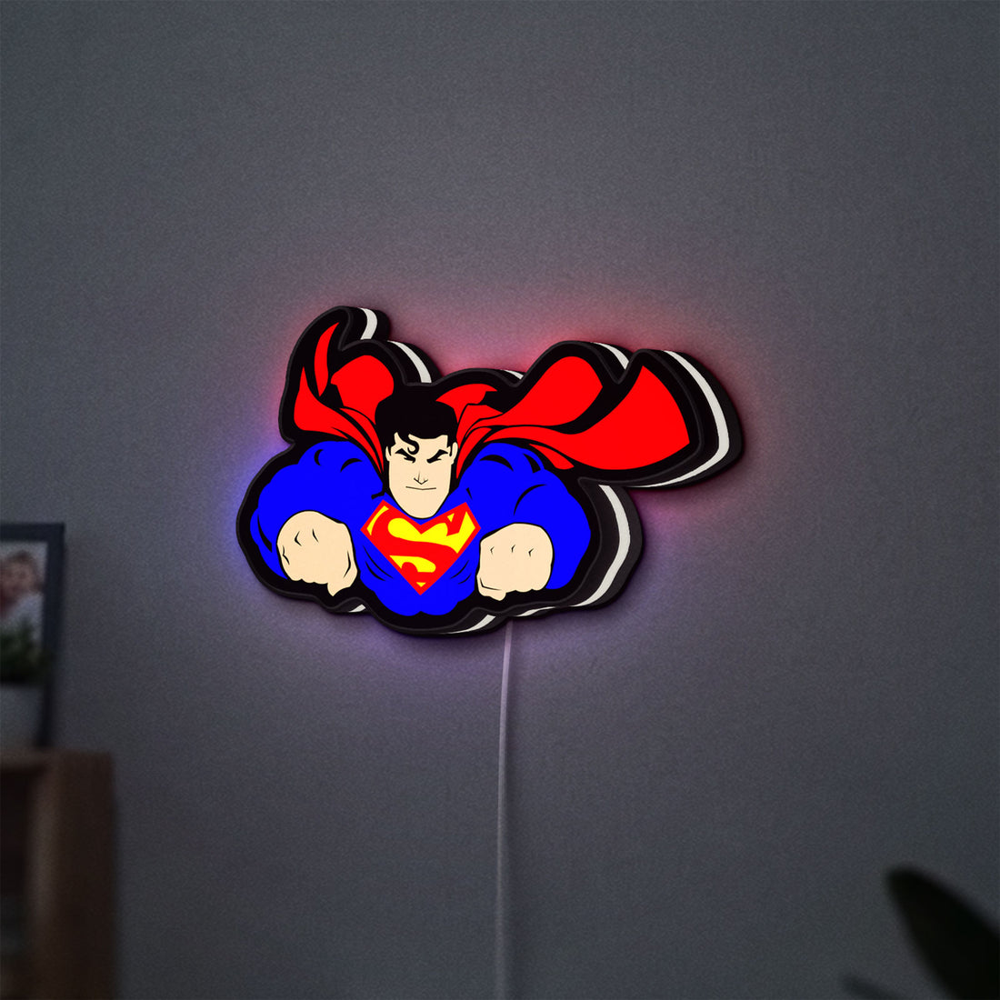 Superman S Shield LED lightbox hanging on a wall with white glow